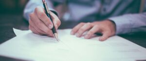 man writing on paper