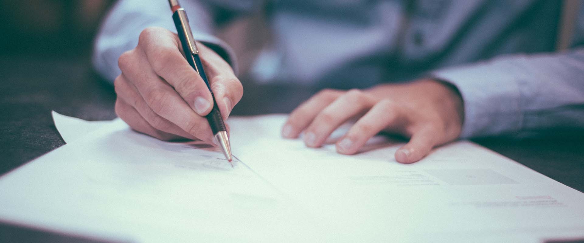 man writing on paper