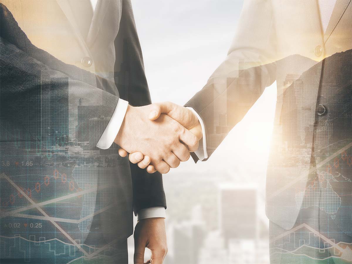business handshake with stock market graph overlay