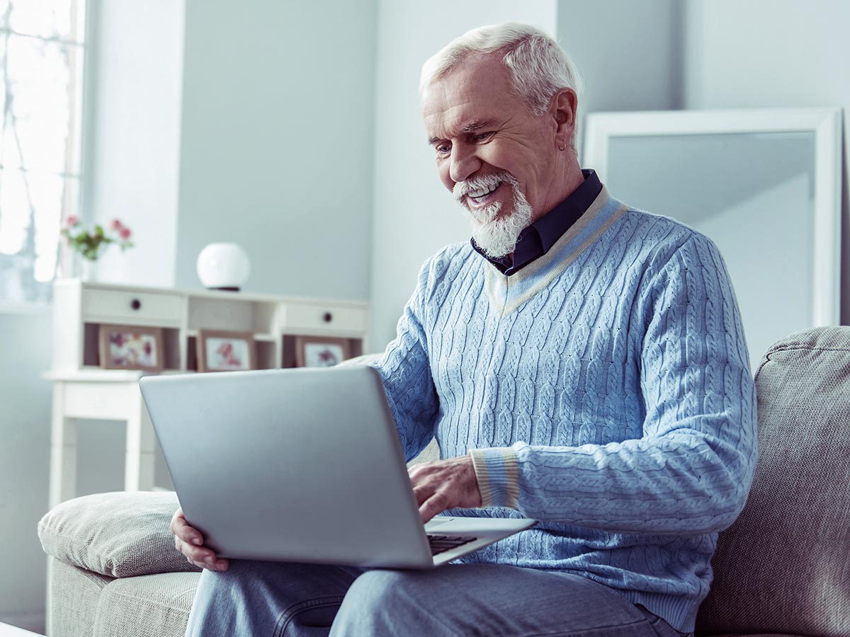Happy senior man using a laptop