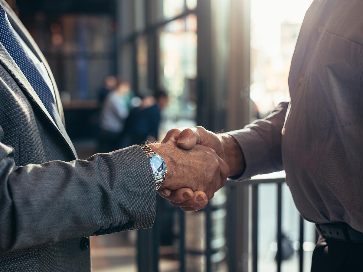 Two senior men shaking hands