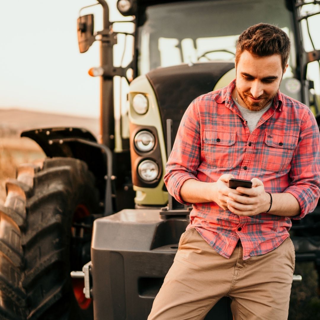 man in front of tractor on phone