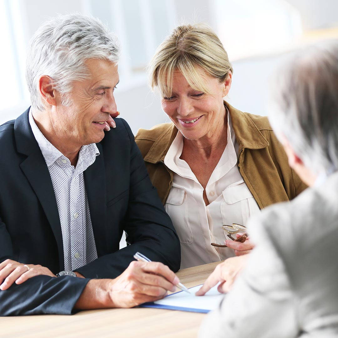 happy senior couple going over documents with a banker