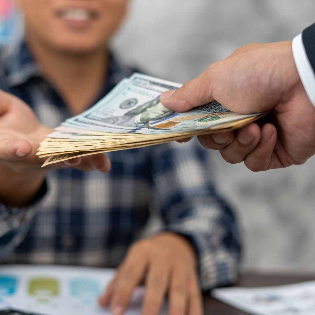 person handing money to another person