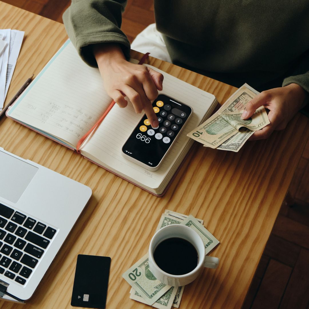 a person using a calculator and counting cash