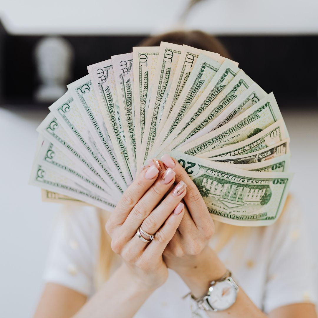 a person fanning money over their face