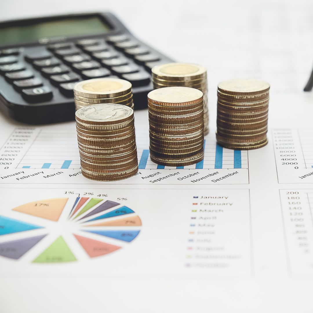 stacks of coins and a calculator on charts
