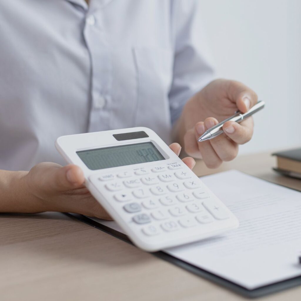 A person pointing to a calculator