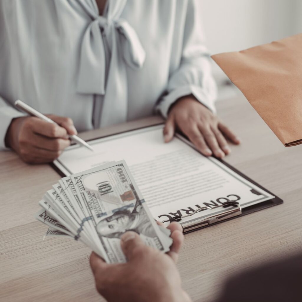 People exchanging money and signing a contract