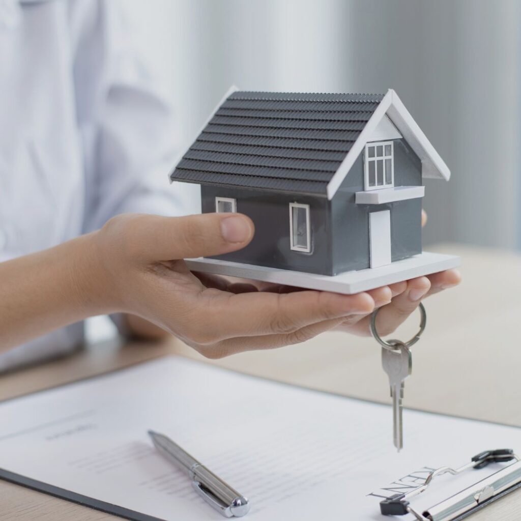 A person holding a miniature model of a house