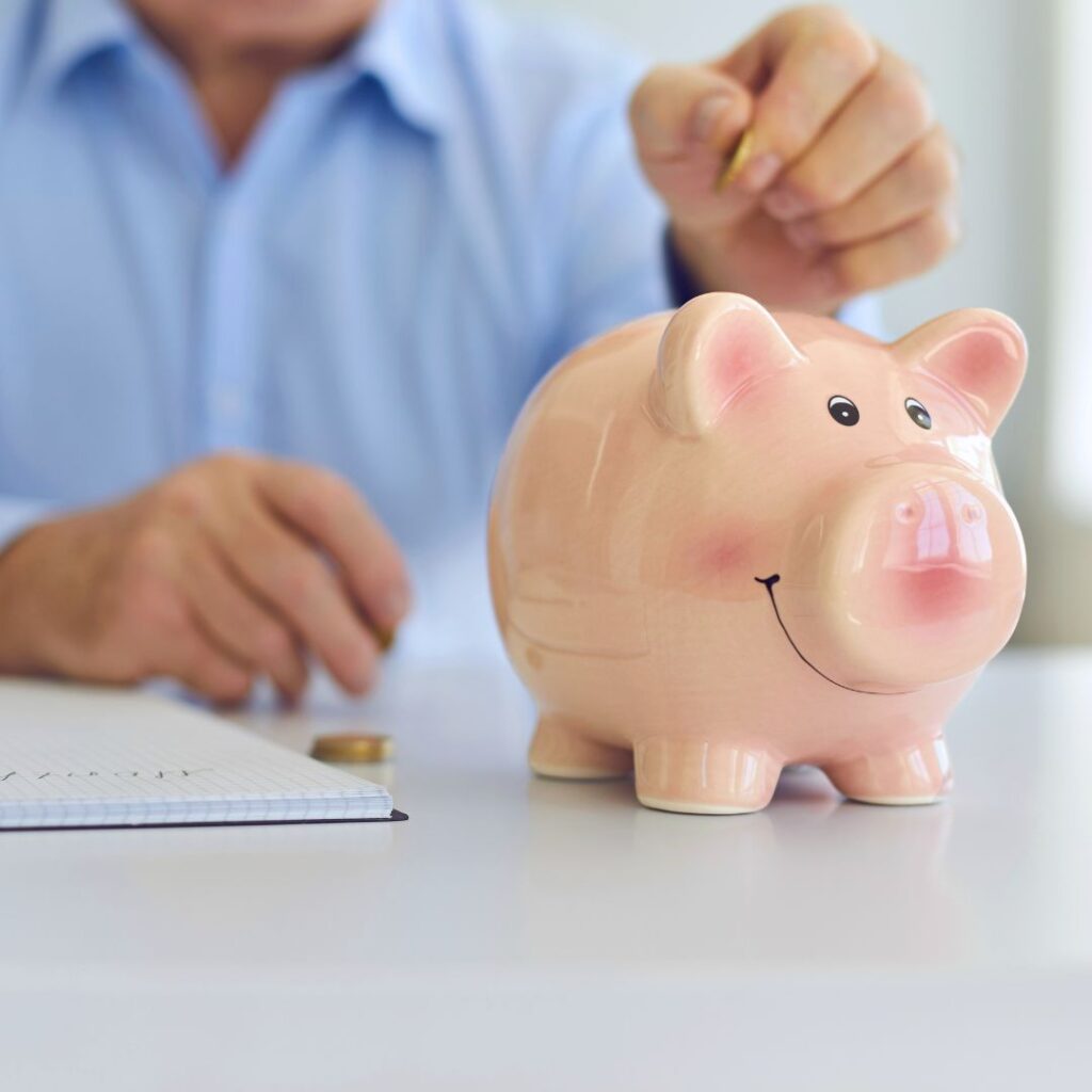 A man putting coins in a piggy bank