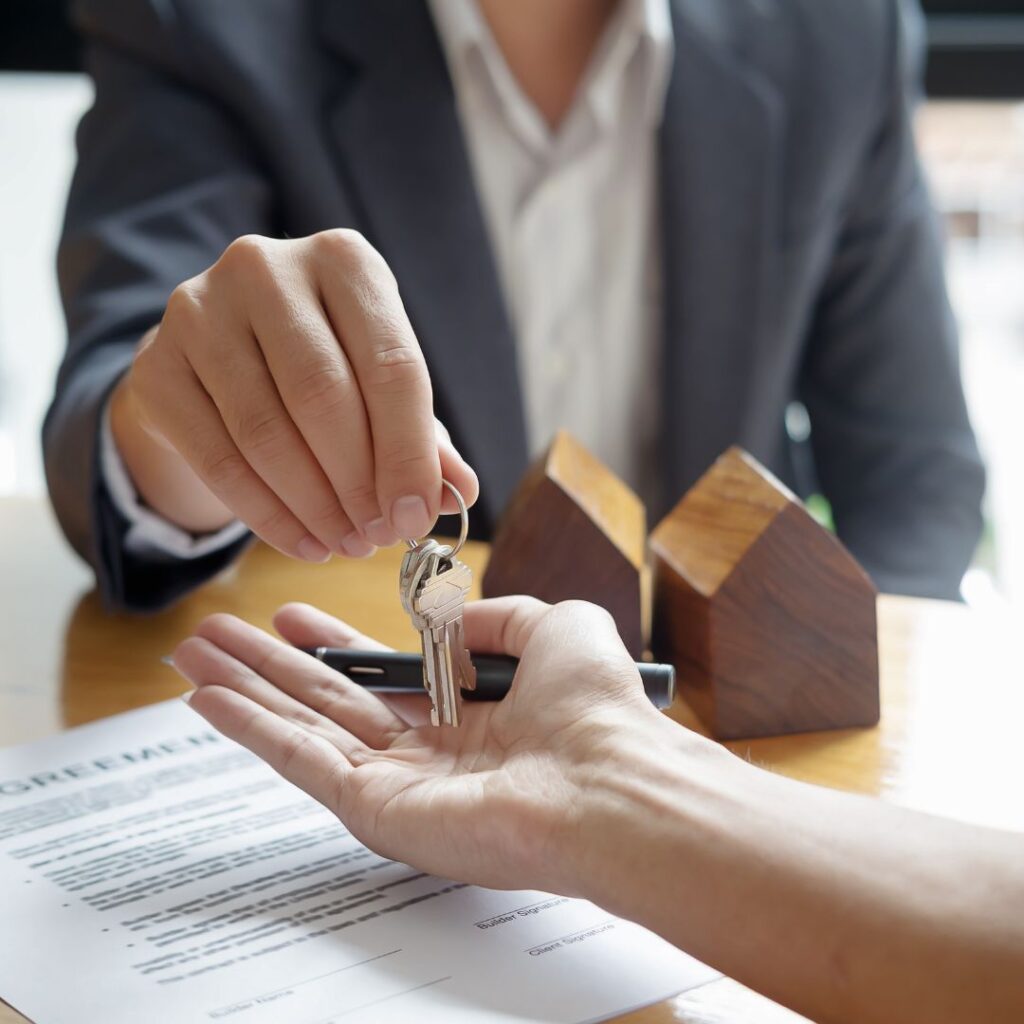 A person handing house keys to another person
